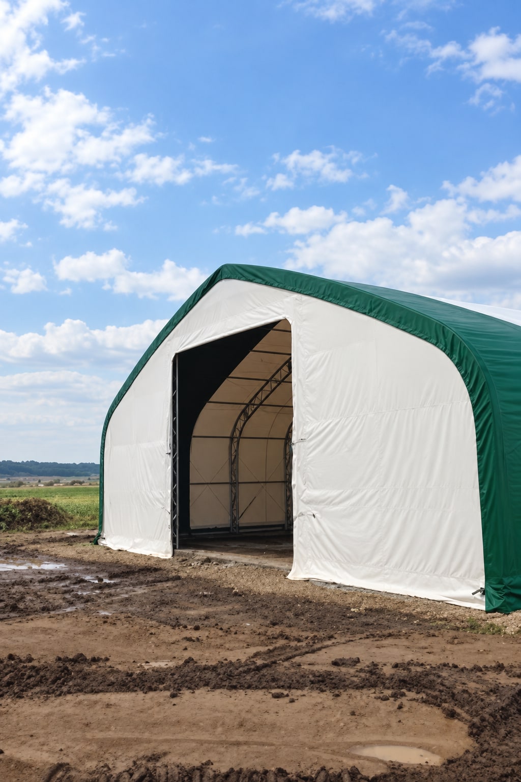 White fabric building with green trim and a raised door