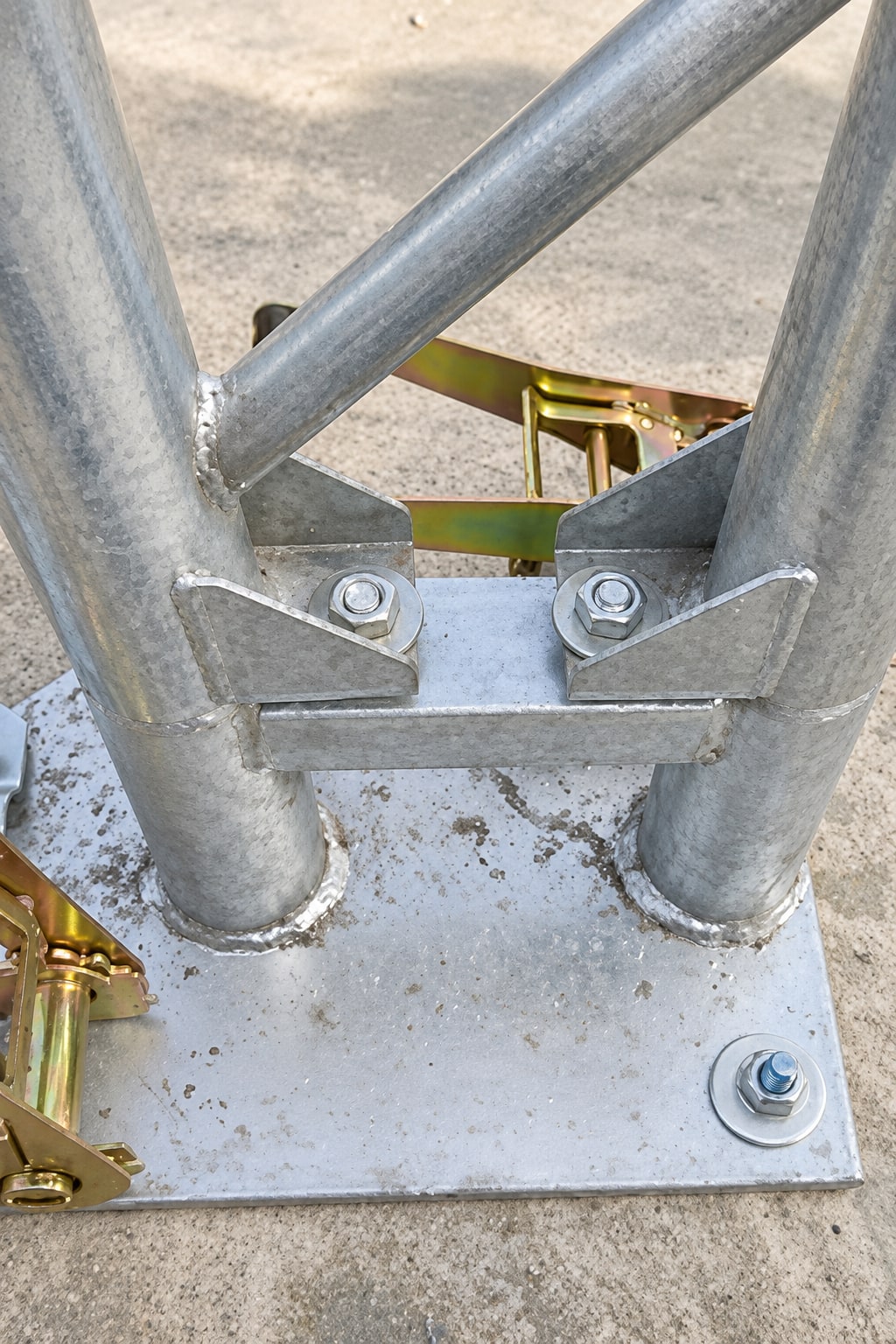 Close view of galvanized steel members bolted to a base plate