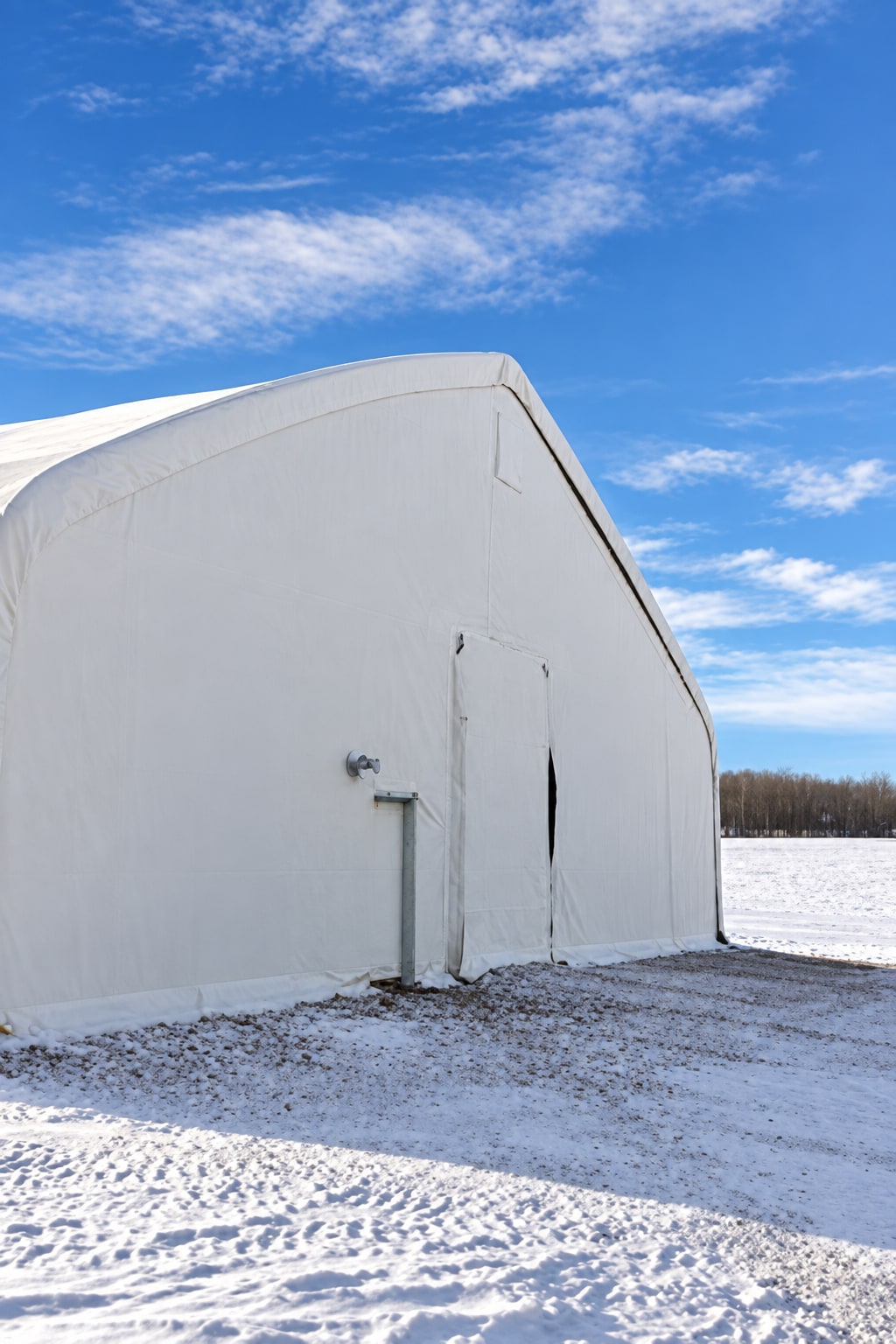 Closed white endwall with a small pedestrian door beside the larger opening
