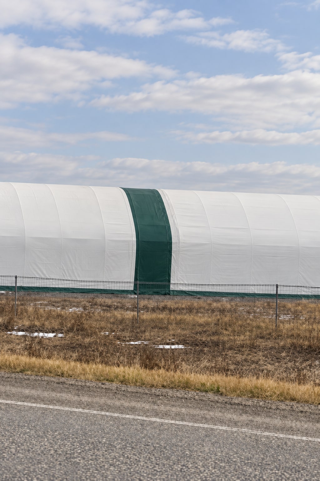Long side view of a covered building with green end trim