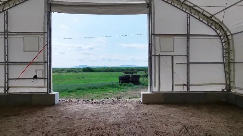 View through the farm building doorway toward the fields