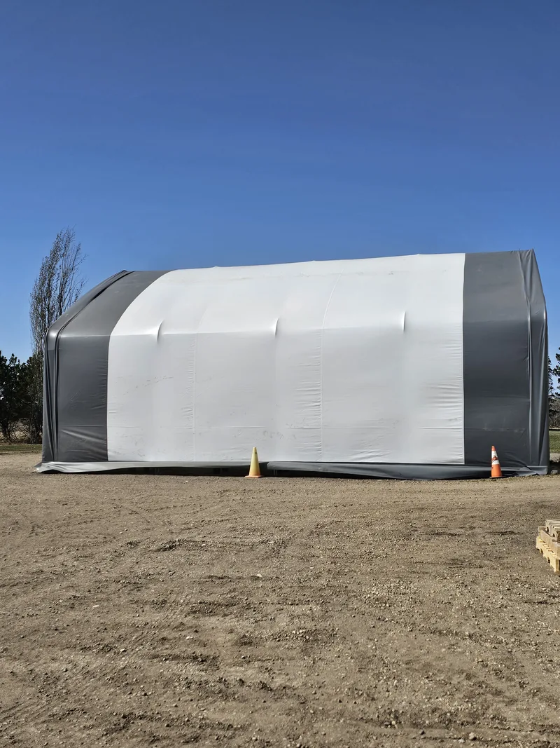 Side view of a white fabric building with grey end trim